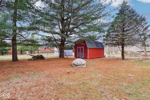 view of yard featuring a shed, fence, and an outbuilding