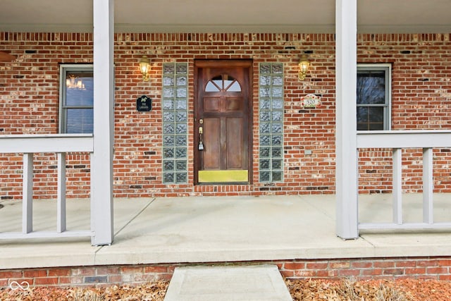 view of exterior entry featuring brick siding