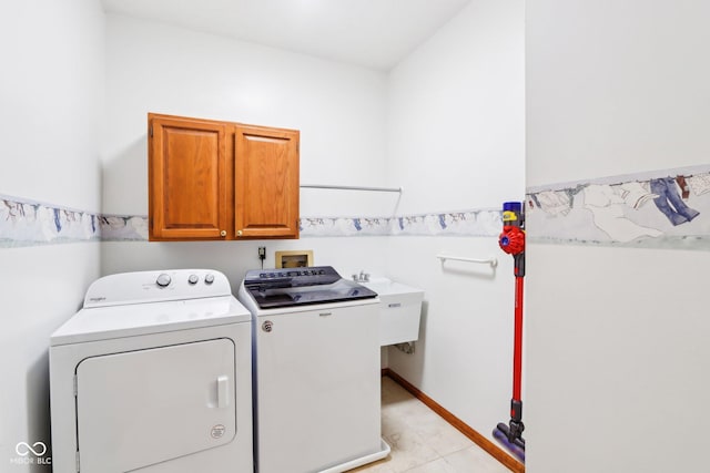 laundry area with baseboards, a sink, cabinet space, and washer and dryer