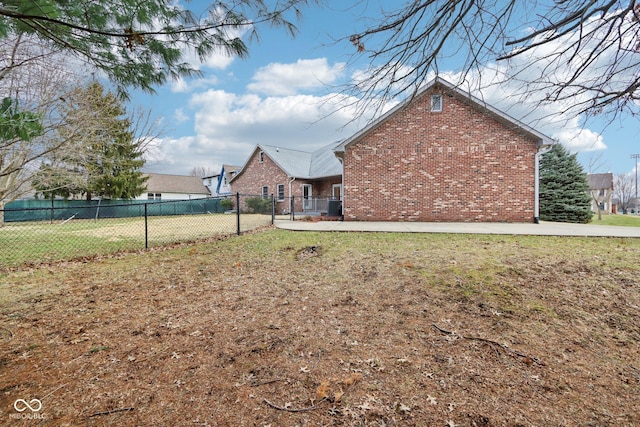 exterior space with fence, a lawn, and brick siding