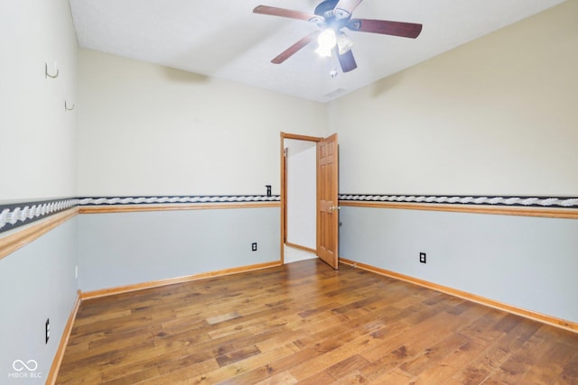 empty room with a ceiling fan, hardwood / wood-style flooring, and baseboards