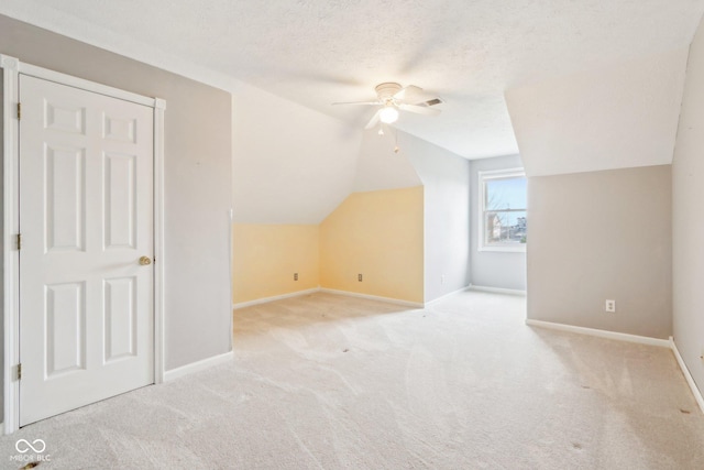 bonus room featuring lofted ceiling, baseboards, a textured ceiling, and carpet flooring