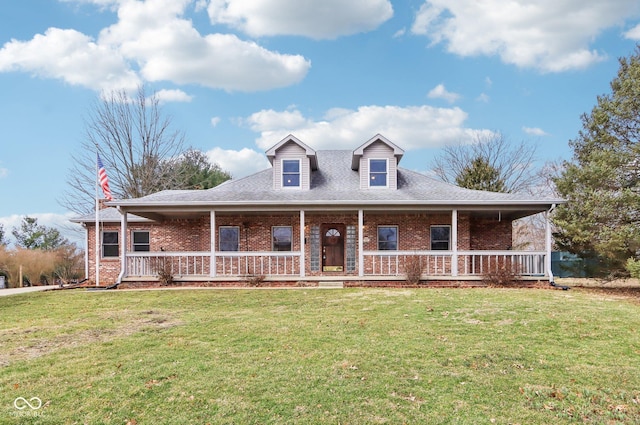 view of front of house with a porch, a front lawn, and brick siding