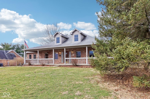 view of front facade with a front yard, covered porch, and brick siding