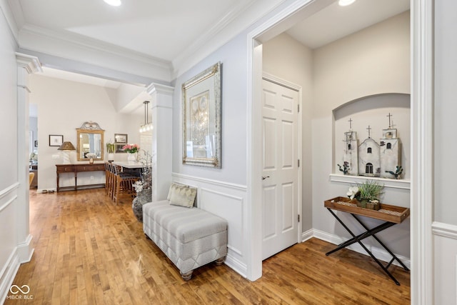 foyer with crown molding and light wood finished floors