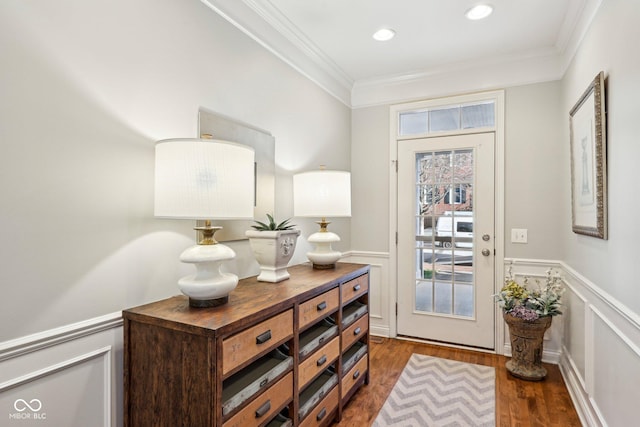 entrance foyer with a wainscoted wall, wood finished floors, recessed lighting, crown molding, and a decorative wall