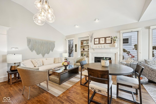 living room with a fireplace, high vaulted ceiling, and wood-type flooring