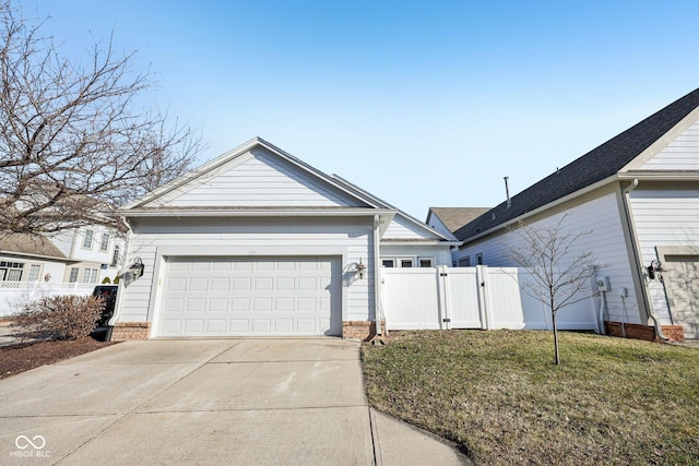 view of front of house with a front lawn, driveway, a gate, fence, and an attached garage