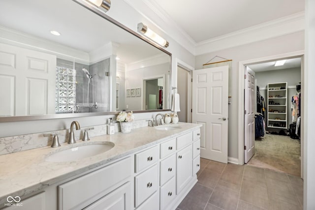 bathroom featuring double vanity, ornamental molding, a tile shower, and a sink