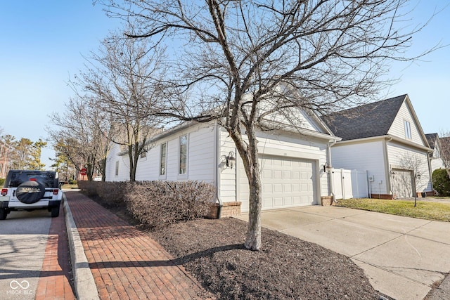 view of side of property featuring an attached garage and concrete driveway