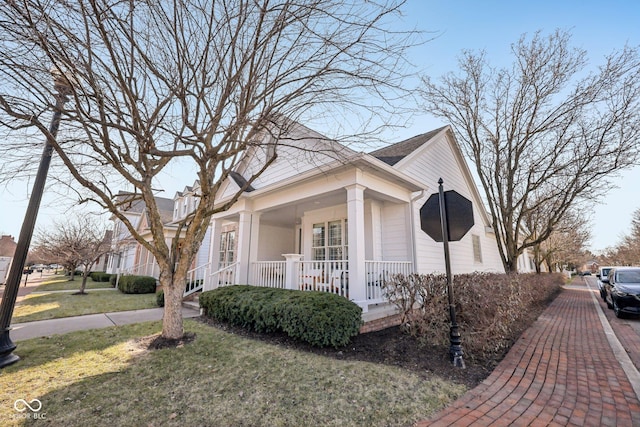 view of side of property with a lawn and covered porch