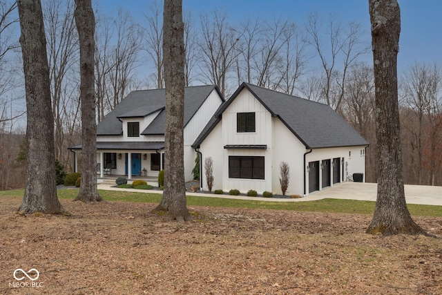 modern farmhouse featuring driveway, covered porch, a shingled roof, and board and batten siding