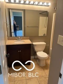 full bath with tile patterned flooring, toilet, vanity, and a shower