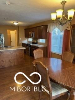 unfurnished dining area with a chandelier and wood finished floors