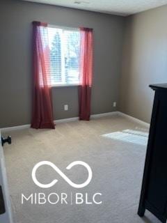 carpeted spare room with baseboards