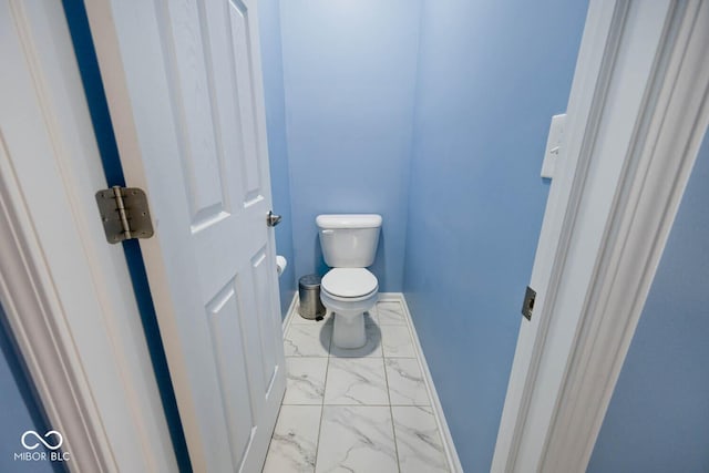 bathroom with marble finish floor, toilet, and baseboards