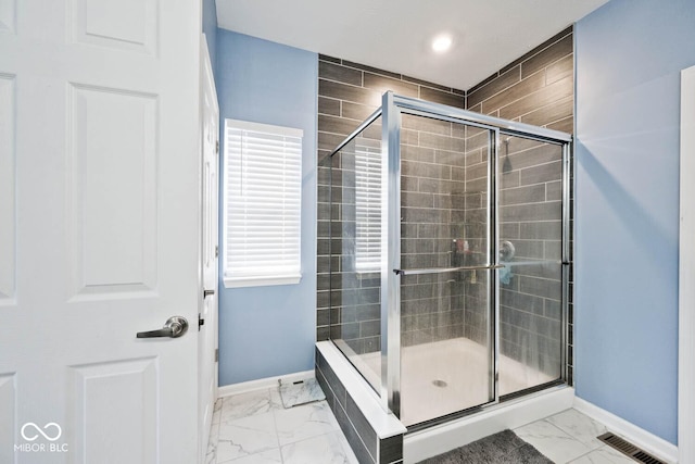 full bathroom with marble finish floor, baseboards, visible vents, and a shower stall