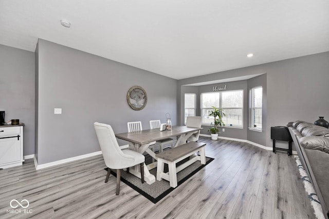 dining space with light wood-style floors and baseboards