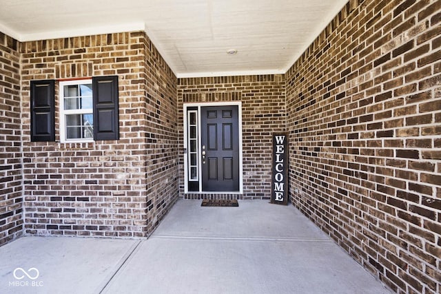 view of exterior entry with brick siding