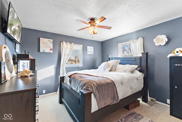 carpeted bedroom with a ceiling fan, baseboards, and a textured ceiling