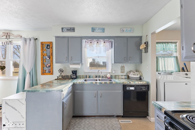 kitchen featuring a sink, independent washer and dryer, dishwasher, and gray cabinetry