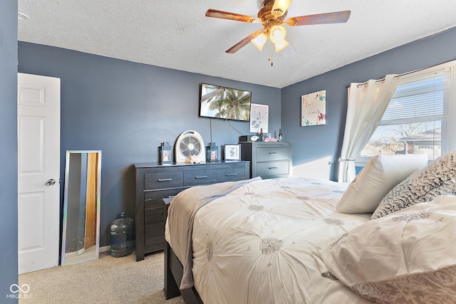 bedroom with a ceiling fan, light carpet, and a textured ceiling