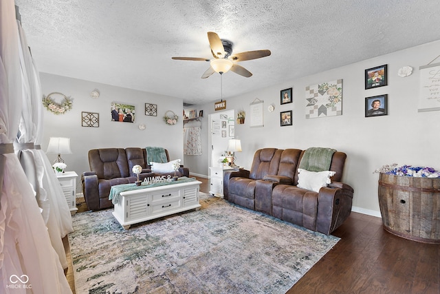 living area featuring a ceiling fan, a textured ceiling, baseboards, and wood finished floors