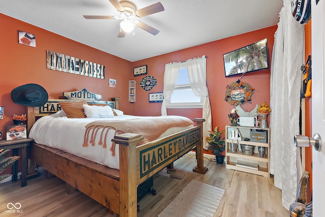 bedroom with ceiling fan, a textured ceiling, and wood finished floors