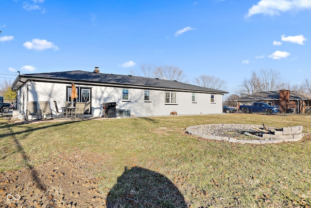 back of house featuring central AC, a lawn, a patio area, and stucco siding