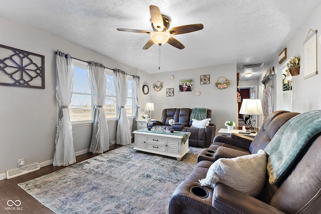 living area with ceiling fan, wood finished floors, visible vents, and baseboards