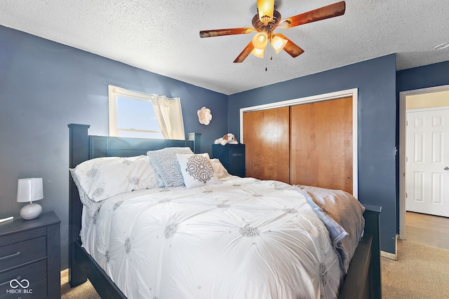 carpeted bedroom with a closet, ceiling fan, and a textured ceiling