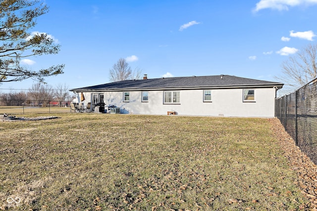 back of property with stucco siding, a fenced backyard, a yard, and a patio