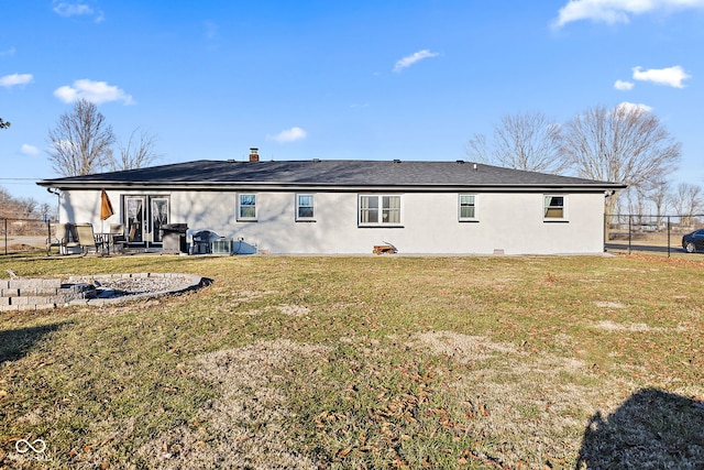 rear view of property featuring a lawn, a patio, and fence