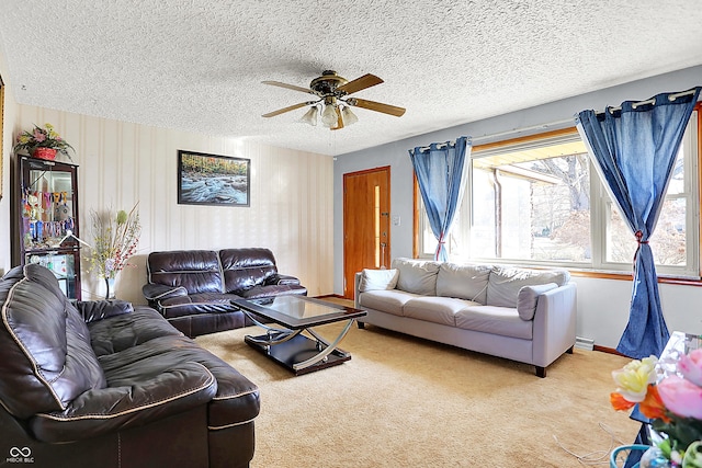 living room with a textured ceiling, carpet flooring, a ceiling fan, and baseboards