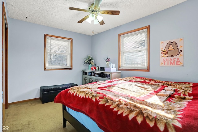 carpeted bedroom with a ceiling fan, baseboards, and a textured ceiling