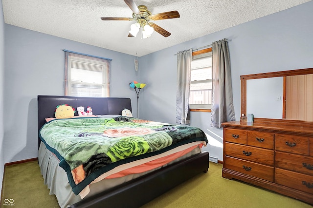 bedroom with a ceiling fan, baseboards, a textured ceiling, and light colored carpet