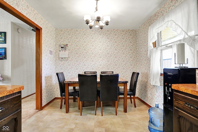 dining space with wallpapered walls, baseboards, and a chandelier