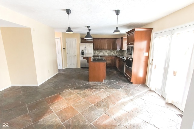 kitchen featuring tasteful backsplash, a center island, hanging light fixtures, stone finish flooring, and stainless steel appliances