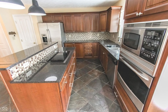 kitchen with a kitchen island, a sink, appliances with stainless steel finishes, decorative backsplash, and dark stone countertops