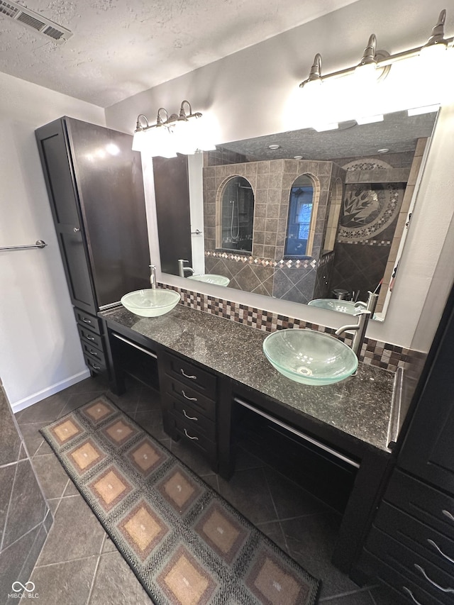 full bath featuring backsplash, a sink, visible vents, and tile patterned floors