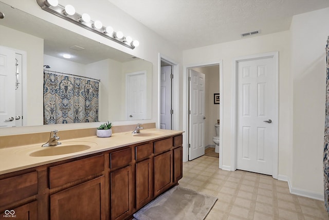 bathroom with a sink, visible vents, toilet, and tile patterned floors