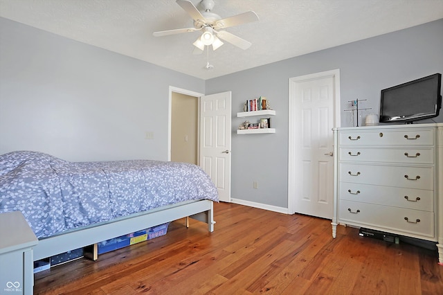 bedroom featuring a ceiling fan, baseboards, and wood-type flooring