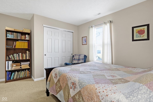 bedroom with visible vents, baseboards, carpet, and a closet