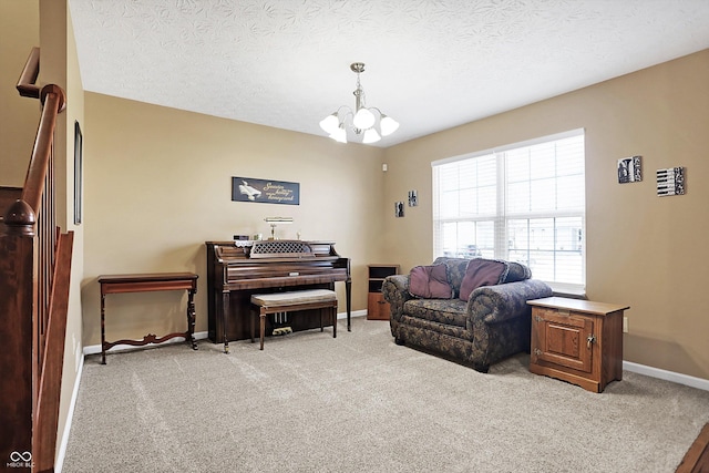 sitting room with baseboards, light colored carpet, an inviting chandelier, and a textured ceiling