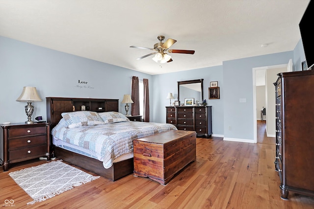 bedroom featuring baseboards, light wood-style floors, and a ceiling fan