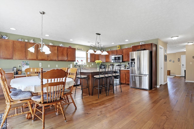 dining space with baseboards, a chandelier, recessed lighting, hardwood / wood-style flooring, and a textured ceiling