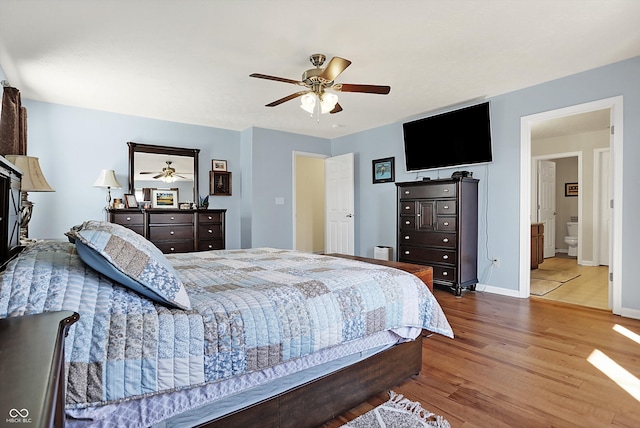 bedroom featuring connected bathroom, wood finished floors, baseboards, and ceiling fan