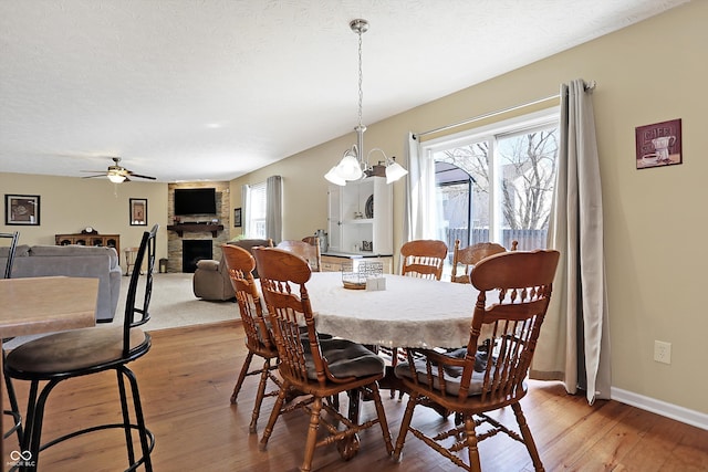 dining area featuring a wealth of natural light, a large fireplace, and light wood-style floors