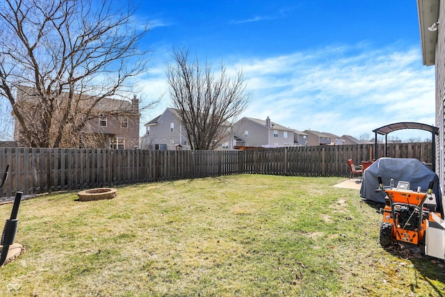 view of yard with a residential view, a fire pit, and a fenced backyard