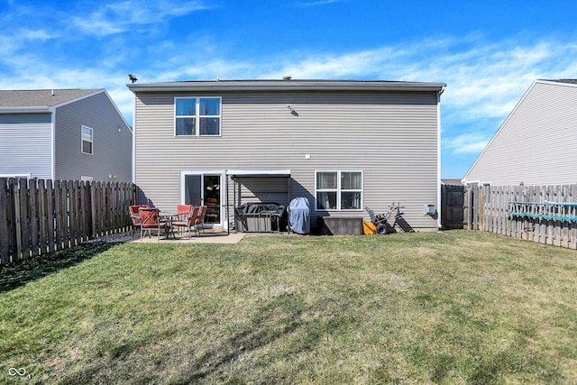 back of property with a patio, a lawn, and a fenced backyard